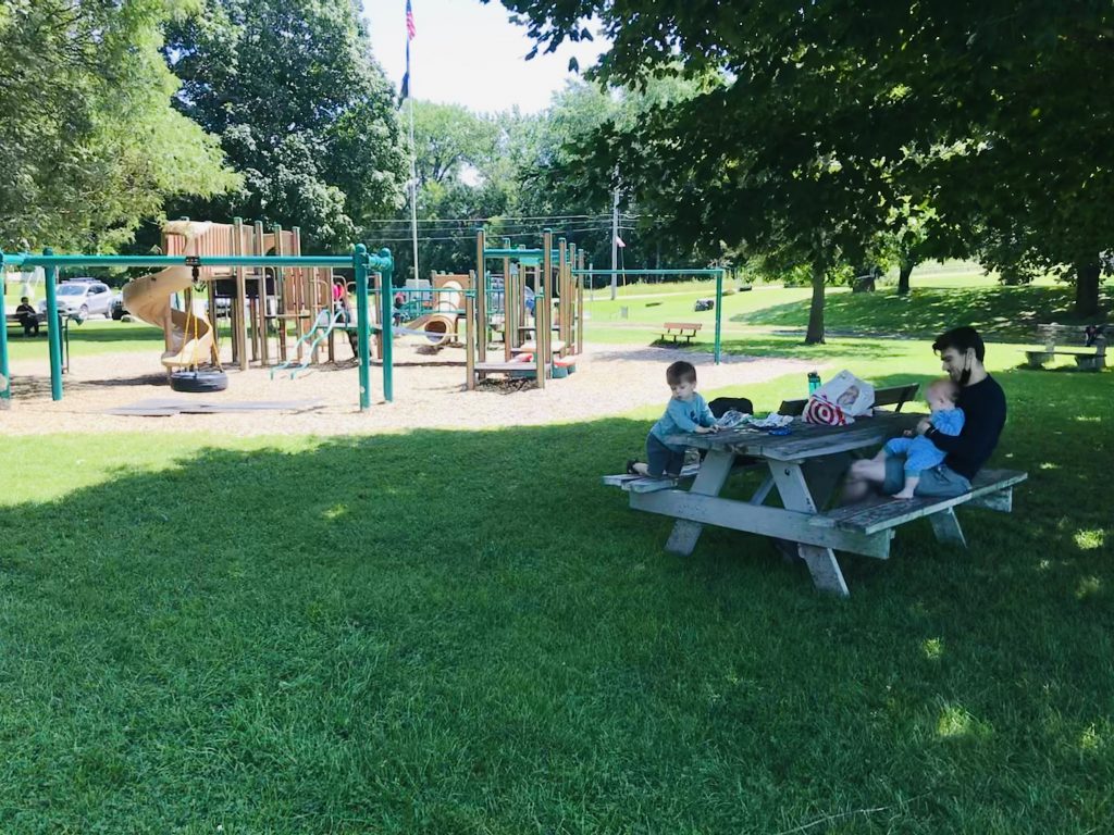 family at a picnic table at a Vermont playground during the summer