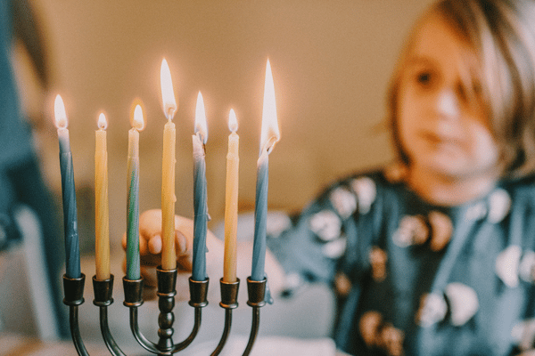 a child lights a menorah