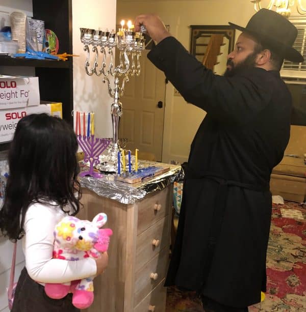Father and daughter lighting the menorah Lighting the Menorah