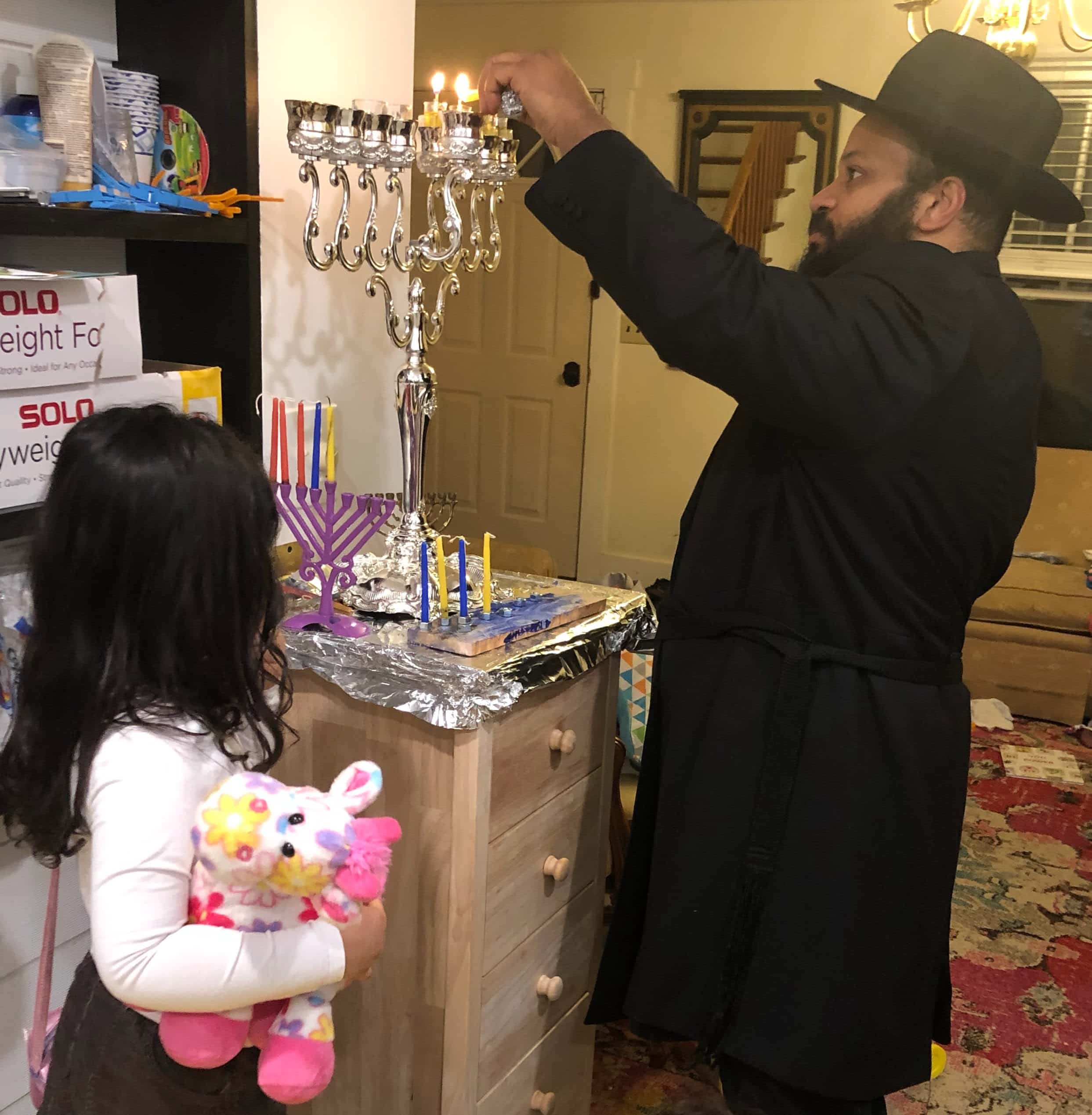 Father and daughter lighting the menorah Lighting the Menorah