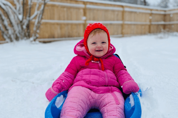 Baby outside in a sled during winter