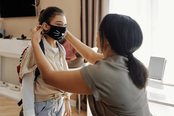 mother putting mask on daughter