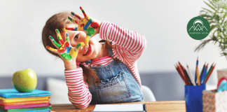 Vermont Guide to Preschools in Burlington and Beyond Preschool-aged girl smiling with paint on her hands