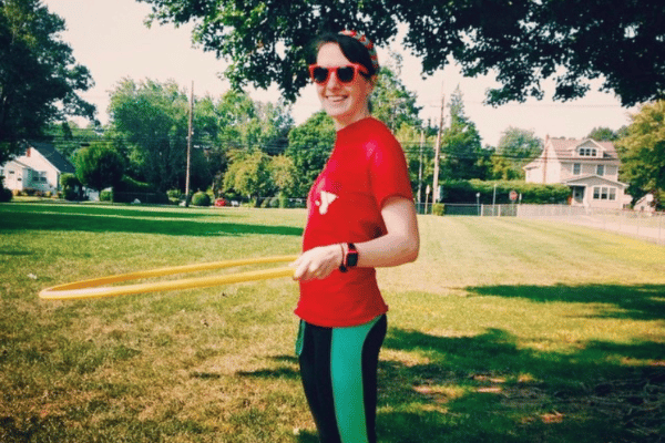 A girl using a hula hoop in a big field