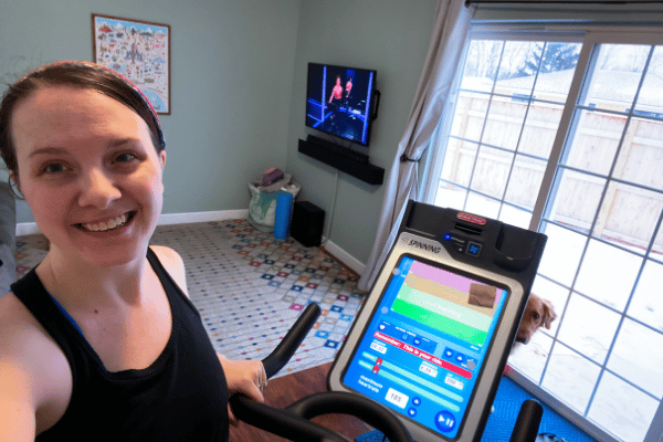 Working out on an indoor bicycle with peloton on in background