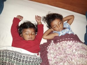 Two toddler girls sleeping in bed together