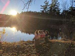Friends watching the sunset together by the lake