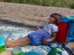 Little girl relaxing on a picnic blanket