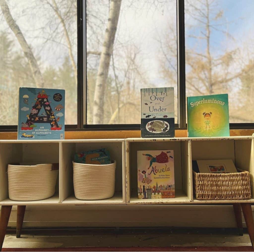 Books on top of a child's toy and craft storage shelf