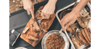 Cooking While Camping: Meals the Whole Family Will Love & Tips You Need slicing meat on cutting board next to side dish
