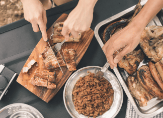 Cooking While Camping: Meals the Whole Family Will Love & Tips You Need slicing meat on cutting board next to side dish