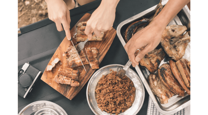 Cooking While Camping: Meals the Whole Family Will Love & Tips You Need slicing meat on cutting board next to side dish
