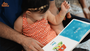 parent holding a toddler and reading aloud