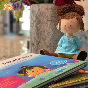 Stack of Little Patakha children's books and doll