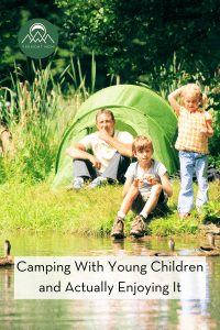 Family sitting in front of a tent by the water