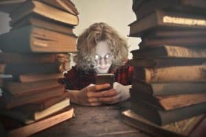 Woman surrounded by books and searching on phone