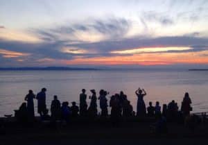 Friends watching the sunset by the lake together