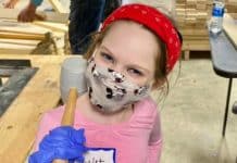How and Why I Started Volunteering with My Child young girl doing volunteer work with a mallet