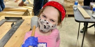How and Why I Started Volunteering with My Child young girl doing volunteer work with a mallet