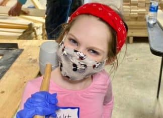 young girl doing volunteer work with a mallet