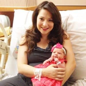 Red lipstick woman holding newborn