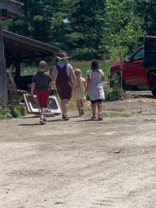 Children walking to gather eggs with a staff member of New Village Farm