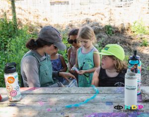 New Village Farm staff teach children how to make raw wool bracelets