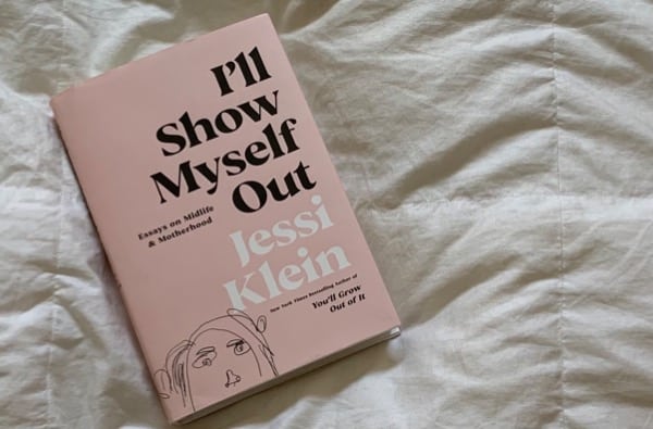 Jessi Klein’s book “Ill Show Myself Out” lies on a white bedspread