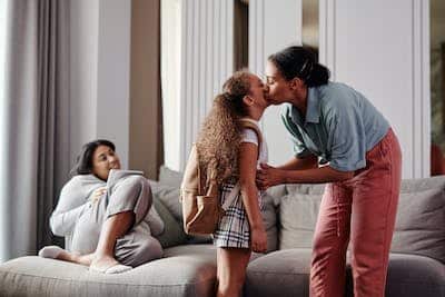 mom kissing her daughter goodbye before school
