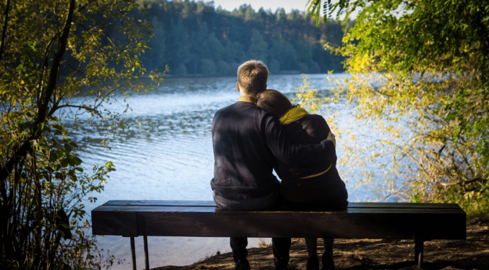 Couple looking out at a lake together.