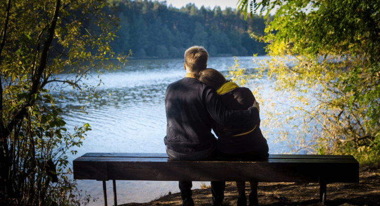 Couple looking out at a lake together.