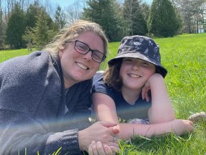 mother and daughter lying on the grass