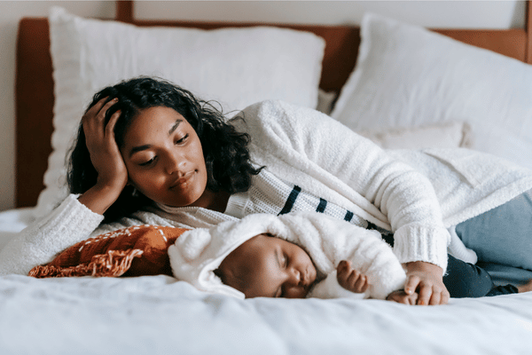 Mom laying on bed with baby.