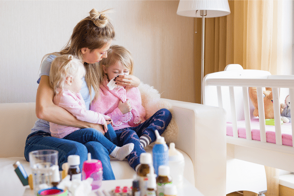 Mom sitting with her two sick kids.