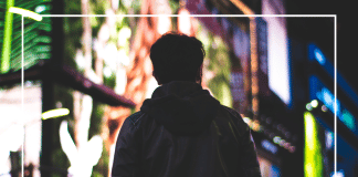 7 Things I Wish I Had Known When My Son Started Applying to College A teenage boy looks down a city sidewalk illuminated by lights.