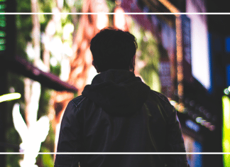 7 Things I Wish I Had Known When My Son Started Applying to College A teenage boy looks down a city sidewalk illuminated by lights.
