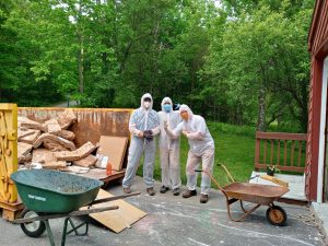 Three men in coveralls doing demolition work