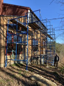 Homeowner looking at house with scaffolding along the entire side