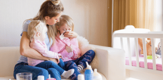 Mom Hacks for Cold and Flu Season Mom sitting with her two sick kids.