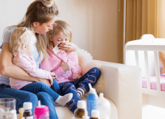 Mom Hacks for Cold and Flu Season Mom sitting with her two sick kids.