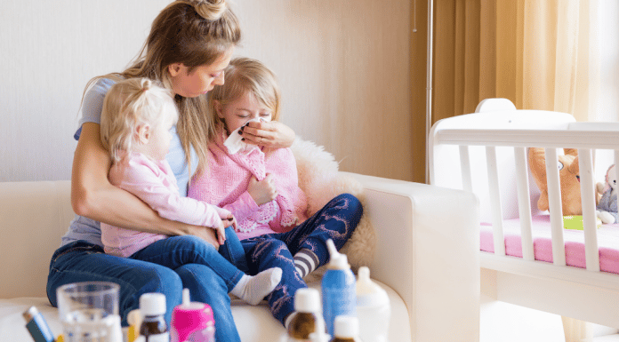 Mom Hacks for Cold and Flu Season Mom sitting with her two sick kids.