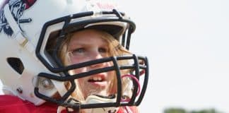 Meet the 8-Year-Old Who is Making Her Presence Known in Flag Football Young girl wearing a football helmet and a red jersey