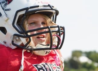 Meet the 8-Year-Old Who is Making Her Presence Known in Flag Football Young girl wearing a football helmet and a red jersey