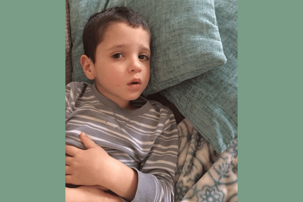 Sick little boy holding his stomach