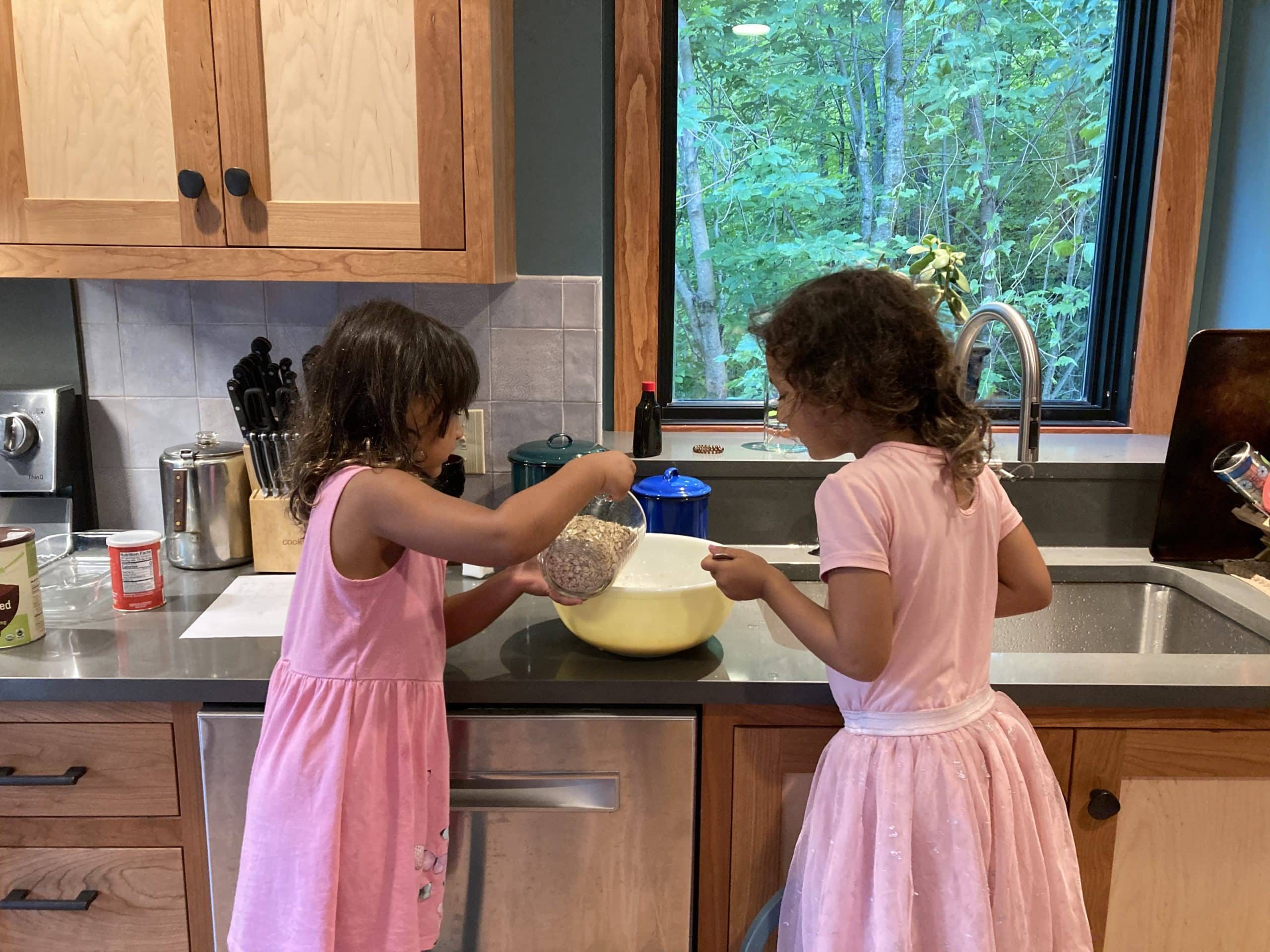 Two girls measuring ingredients for cookies