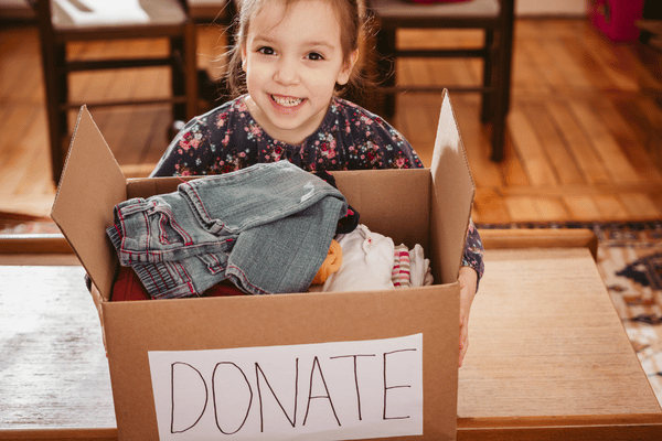 Young girl holding a box labeled "donate".