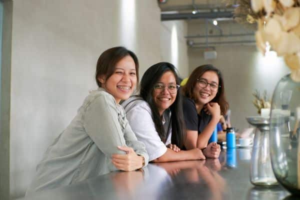 three women sitting at a kitchen counter