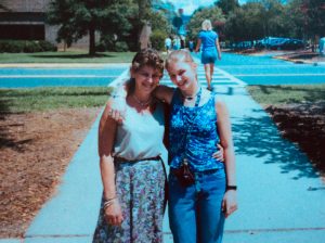 Mother and daughter posing for a photo together outside on sidewalk