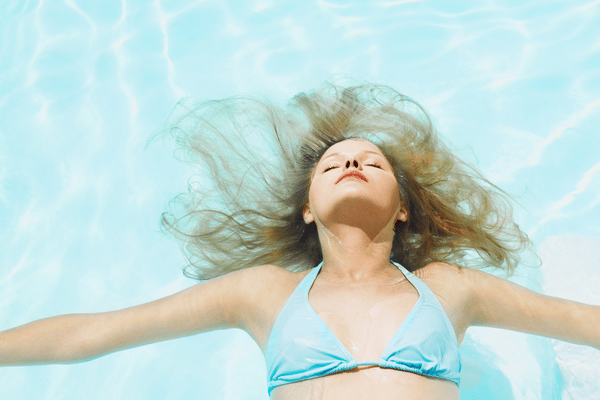 woman floating in the water with her eyes closed