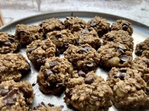 Picture of delicious looking banana and oatmeal chocolate chip cookies on a plate near a window